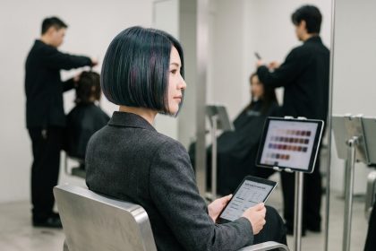 Femme aux cheveux courts holographiques dans un salon de coiffure high-tech avec analyse capillaire numérique